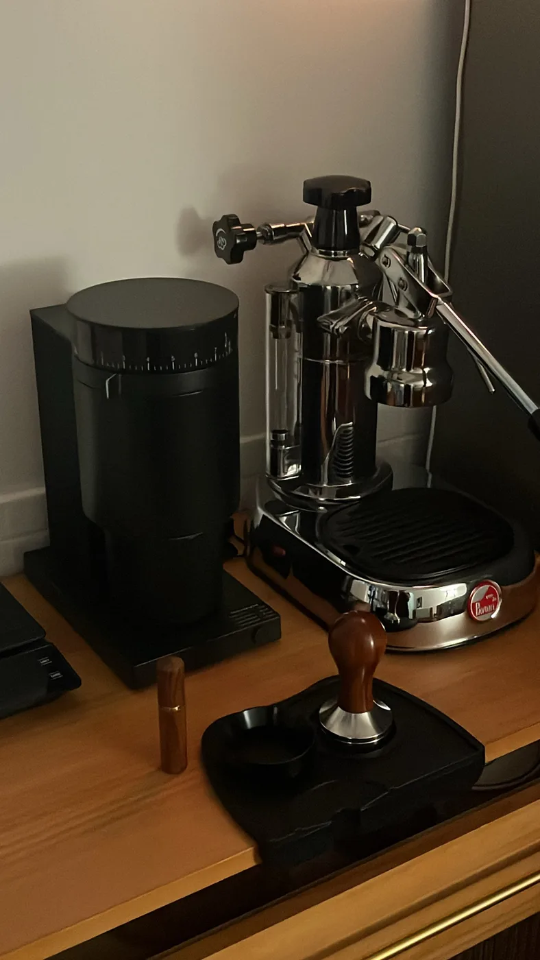 The La Pavoni lever machine on the counter, with grinder and tamper